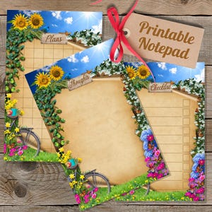 May include: Printable notepad set with a floral and bicycle design. The notepads feature sunflowers, blue skies, and the words "Plans", "Thoughts", and "Checklist". A tag with the words "Printable Notepad" is attached with a red ribbon.