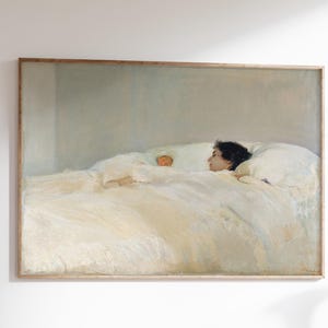 Peut inclure: Une reproduction d'art encadrée représentant une personne au lit, dans des tons doux et sourds. L'œuvre montre une personne aux cheveux foncés reposant dans un lit couvert de draps blancs. L'impression est affichée au-dessus d'un bureau en bois avec une chaise.