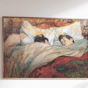 Può includere: Una stampa incorniciata di un dipinto raffigurante due figure a letto, con una calda tavolozza di rossi, marroni e creme. L'opera d'arte è esposta sopra una scrivania in legno, con un vaso bianco e una sedia con cornice dorata.