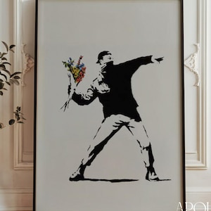 Peut inclure: Impression en noir et blanc d'une figure lançant un bouquet de fleurs colorées. L'œuvre est encadrée dans un cadre noir et porte le texte "APOLLO TIMELESS PRINTS HIGH QUALITY REPRODUCTIONS" en bas.