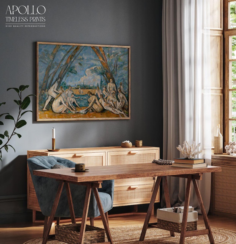 May include: A framed print of a classical painting hangs above a wooden cabinet and desk. The artwork depicts figures in a landscape with blue and green hues. The desk has a blue chair, a coffee cup, and a woven basket. The text "APOLLO TIMELESS PRINTS" is visible.