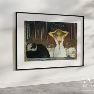 May include: Framed art print featuring a painting of a woman in a white dress with red accents, standing in a forest. A figure in black lies on the ground. The artwork is set in a black frame and is displayed on a white wall.