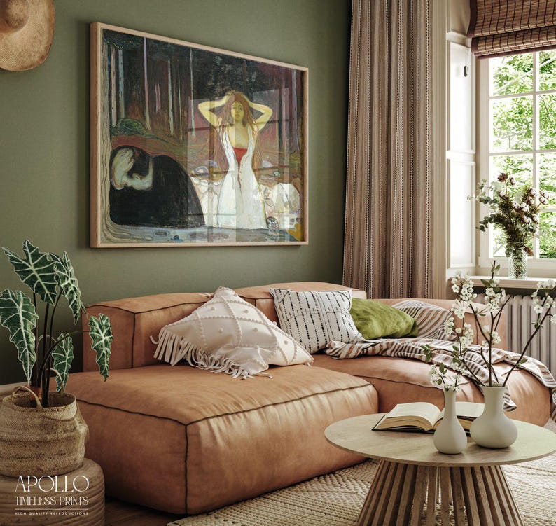 May include: A framed print of a painting hangs above a brown leather sectional sofa. The painting depicts a woman in a white dress. A round wooden coffee table with two white vases and a book sits in front of the sofa. A potted plant is on the left.