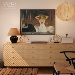 May include: A light wood dresser with six drawers, topped with decorative items and a framed painting. The painting depicts a woman in a white dress with red accents. A woven lamp and a paper lantern hang above.