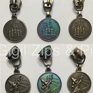 May include: Three sets of zipper pulls with different finishes. The first set features a silver finish with a circular charm depicting Cinderella's castle with the text "Walt Disney World". The second set features a rainbow iridescent finish with a circular charm depicting Cinderella's castle with the text "Walt Disney World". The third set features a bronze finish with a circular charm depicting Mickey Mouse in a sorcerer's hat with the text "Walt Disney World".