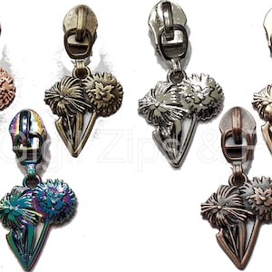 May include: Five zipper pulls with dandelion designs. The pulls are in different finishes: rose gold, antique brass, silver, rainbow, and copper.