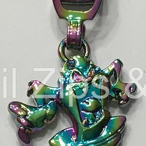 May include: A rainbow iridescent zipper pull with a cartoon tornado design. The tornado is green, blue, and purple with a black outline.
