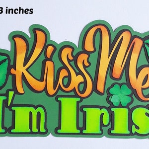 May include: Green and orange paper craft with the text "Kiss Me I'm Irish" and two green lips. The craft is 6 1/4 inches by 3 inches.