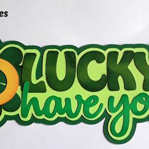 May include: Green and yellow paper craft with the text "So lucky to have you" and a shamrock design. The craft is 16.5 cm by 7.6 cm.