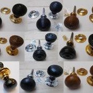 Puede incluir: Una colección de pomos de puerta redondos y estriados en acabados negro y marrón, junto con placas circulares de metal en tonos latón o cromo. Cada pomo presenta una superficie texturizada con ranuras e incluye herrajes de montaje.