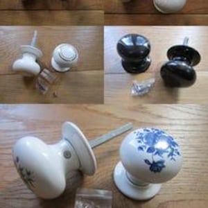 May include: A collection of round door knobs in various finishes including solid white, glossy black, and white with a blue floral pattern. Each knob features a metal spindle and a circular base plate, with some sets including small plastic bags of hardware.