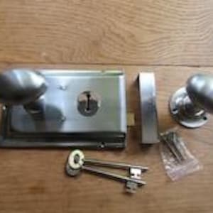 Puede incluir: Un juego de cerradura de sobreponer en tono plateado que incluye un cuerpo rectangular con pomo ovalado, un pomo ovalado a juego sobre placa circular, un cerradero rectangular, dos llaves y una bolsa de plástico con tornillos.