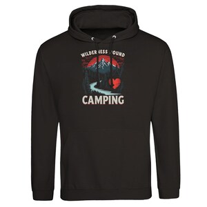 Könnte beinhalten: Schwarzer Kapuzenpullover mit einem Grafikdesign, das eine Bergkette, einen Fluss und Bäume unter einem roten und orangen Sonnenuntergang zeigt. Der Text "WILDERNESS BOUND CAMPING" ist aufgedruckt.