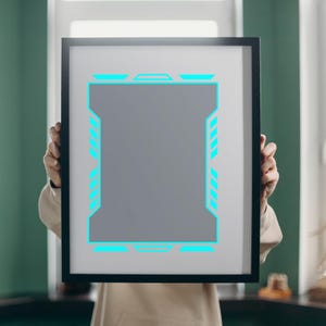 Pu&ograve; includere: Un'opera d'arte incorniciata con un centro grigio e un bordo geometrico blu neon. La cornice nera contiene l'opera d'arte, che &egrave; tenuta da una persona. L'opera d'arte ha un design futuristico di ispirazione tecnologica.