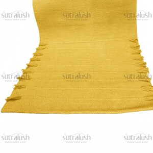 May include: Mustard yellow woven rug with horizontal stripes and fringe detailing along the edge. The rug has the text "sutralush" repeated across the image.