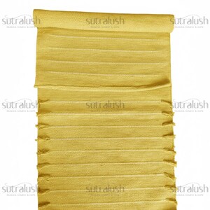May include: A rolled-up, yellow rectangular rug with horizontal stripes and fringed edges. The rug has the text "sutralush PASSION, ENERGY & HOPE" printed on it multiple times.