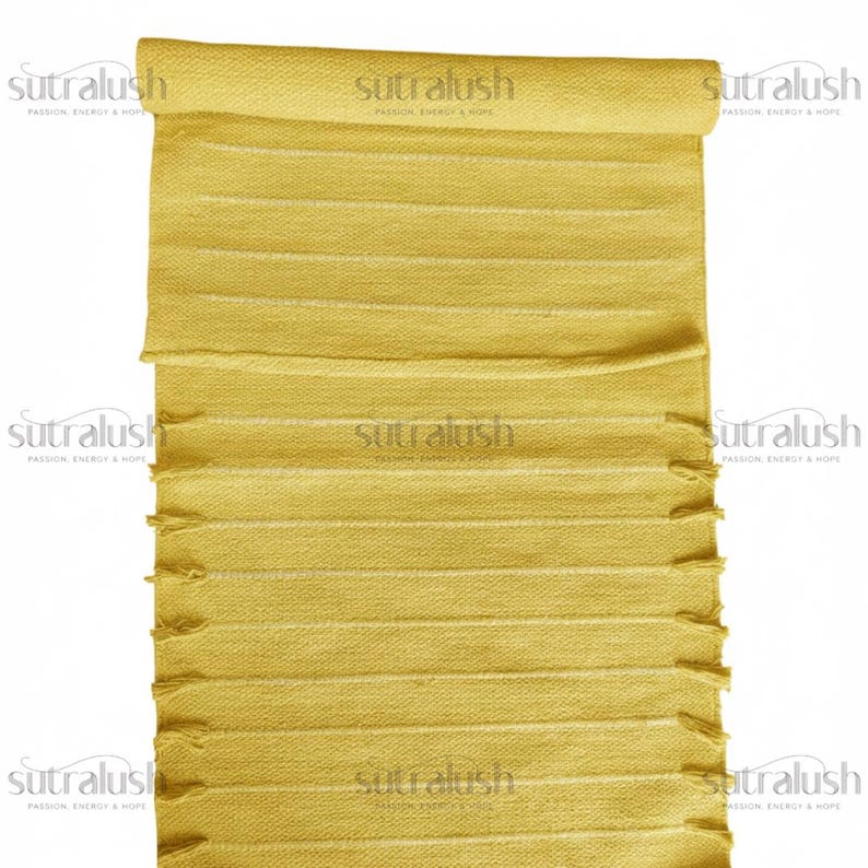 May include: A rolled-up, yellow rectangular rug with horizontal stripes and fringed edges. The rug has the text "sutralush PASSION, ENERGY & HOPE" printed on it multiple times.