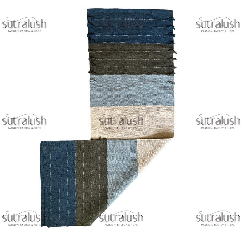 Peut inclure: Un tapis tiss&eacute; multicolore avec un motif &agrave; rayures. Le tapis pr&eacute;sente des nuances de bleu, de vert et de beige. Le texte "sutralush PASSION, ENERGY & HOPE" est imprim&eacute; sur le tapis. Le tapis a un bord effiloch&eacute;.