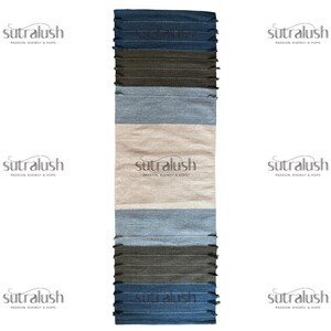 Peut inclure: Un tapis rectangulaire &agrave; rayures avec un aspect textur&eacute;. Le tapis pr&eacute;sente des bandes de bleu, de gris et de beige. Les bords sup&eacute;rieur et inf&eacute;rieur ont une frange. La marque "sutralush" est imprim&eacute;e au centre.
