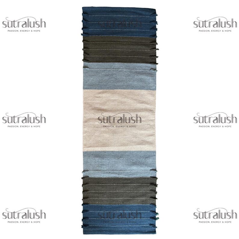 Peut inclure: Un tapis rectangulaire &agrave; rayures avec un aspect textur&eacute;. Le tapis pr&eacute;sente des bandes de bleu, de gris et de beige. Les bords sup&eacute;rieur et inf&eacute;rieur ont une frange. La marque "sutralush" est imprim&eacute;e au centre.