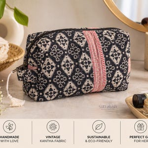 May include: A rectangular zippered pouch made of black and white patterned fabric with a vertical red stripe detail. The pouch features a small side handle with a white tassel pull and displays the text sutralush printed on the lower right side.