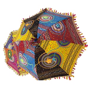 May include: A multi-colored parasol featuring a patchwork design of various fabrics in shades of blue, red, yellow, and black. The canopy is decorated with circular patterns, intricate embroidery, and a fringe border with small colorful tassels.