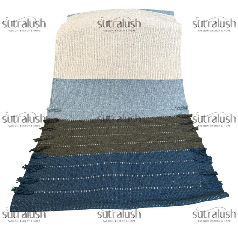 Peut inclure: Textile rectangulaire &agrave; rayures blanches, bleu clair, vert olive et bleu marine. Le textile a un bord &agrave; franges et le texte "sutralush PASSION, ENERGY & HOPE" est visible &agrave; plusieurs endroits.