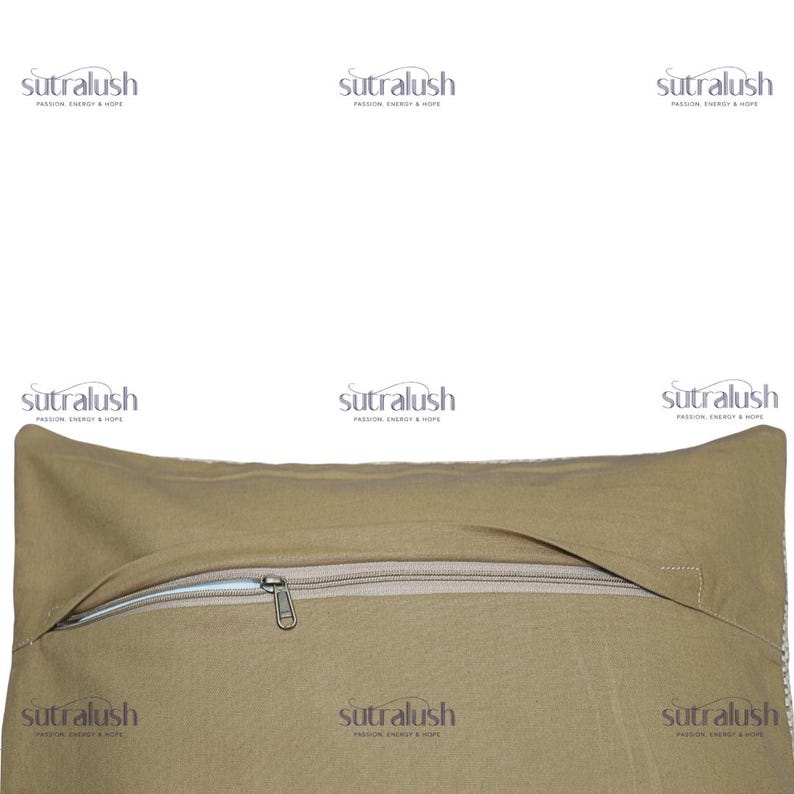 May include: Close-up of a tan pillow with a zipper closure. The pillow has a rectangular shape and a neutral color. The zipper is silver and runs along the top edge of the pillow. The brand name "sutralush" is printed on the pillow.