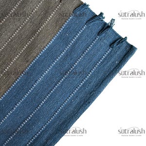 Peut inclure: Deux tapis rectangulaires tiss&eacute;s. L'un est de couleur vert-gris fonc&eacute;, l'autre bleu profond. Les deux ont des rayures verticales blanches et des bords frang&eacute;s. Les tapis sont inclin&eacute;s en diagonale.