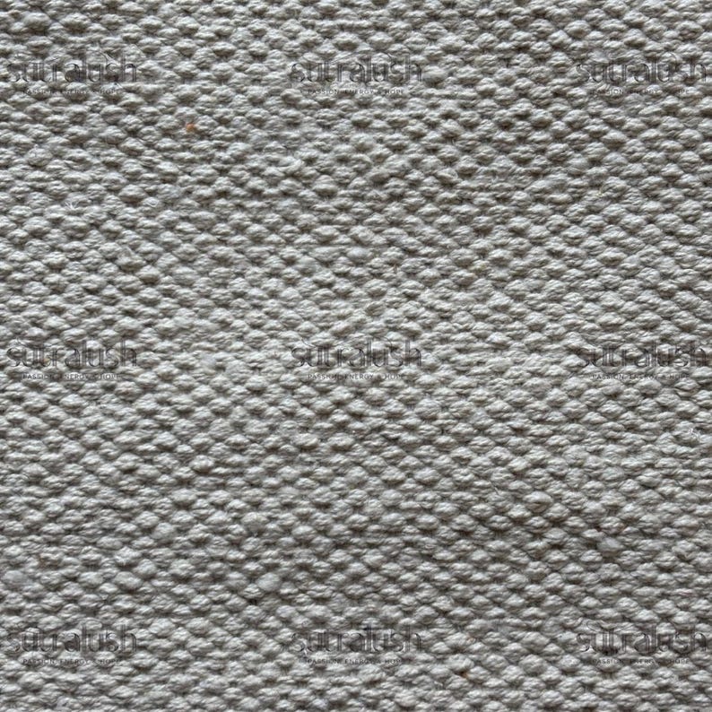 Peut inclure: Gros plan sur un tissu textur&eacute; gris clair. La surface est recouverte de petites bosses en relief, cr&eacute;ant un motif tactile et visuellement int&eacute;ressant. Le tissu semble &ecirc;tre tiss&eacute; serr&eacute;, sugg&eacute;rant une durabilit&eacute;.