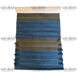 Peut inclure: Un tapis &agrave; rayures enroul&eacute;, avec une section sup&eacute;rieure beige, passant &agrave; des rayures vert olive et bleues. Le tapis a des lignes blanches et des franges sur le bord inf&eacute;rieur. Le nom de la marque "sutralush" est imprim&eacute;.