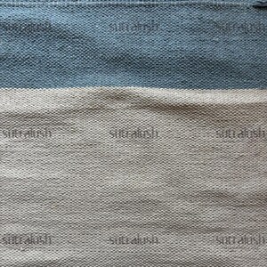 Peut inclure: Textile tiss&eacute; &agrave; surface textur&eacute;e. Le motif pr&eacute;sente des bandes horizontales bleu clair et blanc cass&eacute;. Le mot "sutralush" est imprim&eacute; &agrave; plusieurs reprises sur le textile.