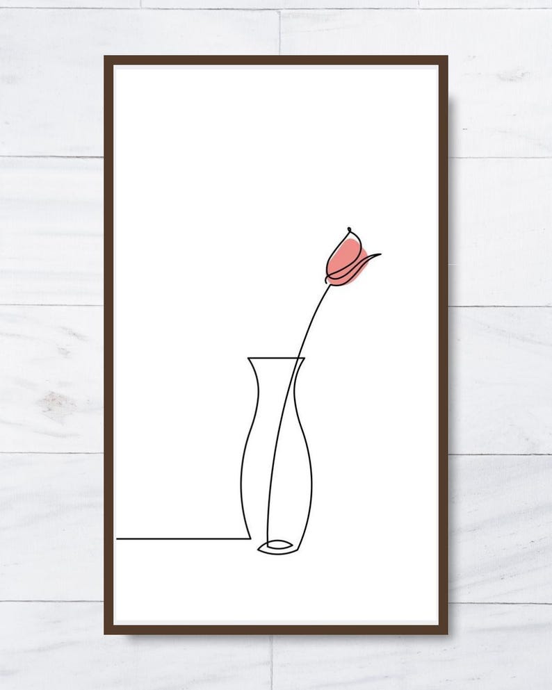 K&ouml;nnte beinhalten: Ein gerahmter minimalistischer Kunstdruck mit einer Ein-Linien-Zeichnung einer Blume in einer Vase. Die Blume hat eine rosa Knospe und die Vase ist schwarz. Das Kunstwerk ist vor einem wei&szlig;en Hintergrund.
