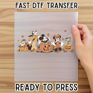 May include: A gray DTF transfer sheet featuring Disney characters Mickey Mouse, Minnie Mouse, Goofy, Donald Duck, and Pluto, each posed with a carved pumpkin. The text "FAST DTF TRANSFER" and "READY TO PRESS" are printed at the top and bottom.