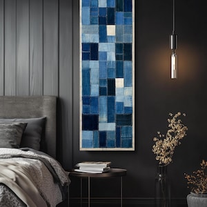 May include: A tall, rectangular wall art piece featuring a patchwork design of various blue fabric squares and rectangles. The textile composition displays a gradient of shades ranging from light sky blue to deep navy, with visible white stitching.