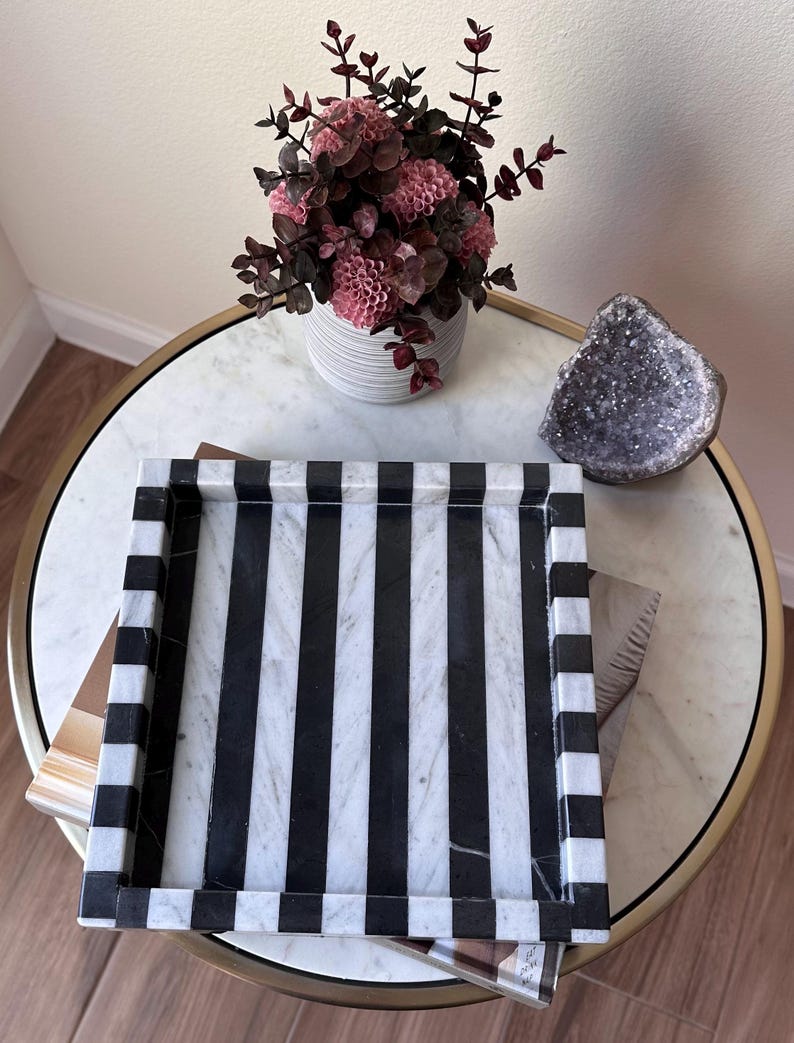 May include: A rectangular tray featuring a bold, alternating vertical stripe pattern in black and white. The tray has raised edges with a matching striped design, constructed from a smooth, polished stone material with visible natural veining.