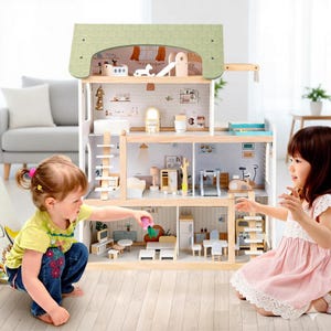 May include: A large wooden dollhouse with multiple rooms, a green roof, and various miniature furniture pieces. Two young children are playing with the dollhouse. The dollhouse has a light wood finish and is filled with small accessories.