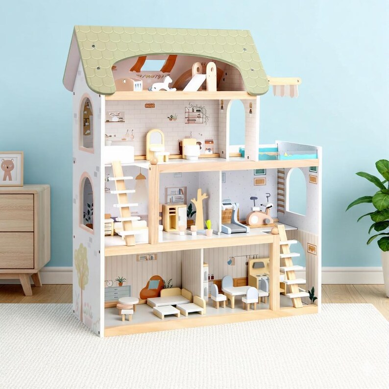 May include: A multi-story wooden dollhouse with a green shingled roof and a light blue background. The dollhouse features multiple rooms with miniature furniture, including a living room, bedroom, and bathroom. The exterior is painted white with decorative tree and arch details.