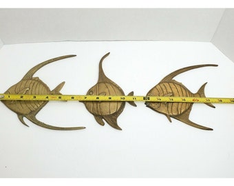 May include: Three gold-toned metal fish wall decor, each with a unique design. The fish are approximately 18 inches long.