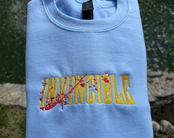 Sudadera de cuello redondo bordada Invincible – Sudadera minimalista inspirada en el anime.