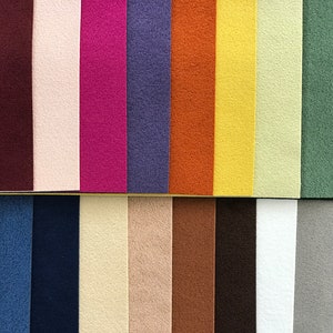 May include: A collection of 20 fabric swatches in various colors, including red, brown, pink, purple, blue, orange, yellow, green, and white. The swatches are arranged in two rows of ten.