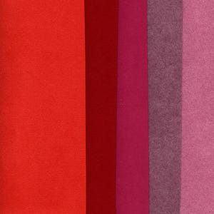 May include: A collection of six rectangular felt sheets in shades of red, pink, and purple. The colors range from bright red to deep burgundy, with varying shades of pink and a muted purple. The felt has a textured surface.