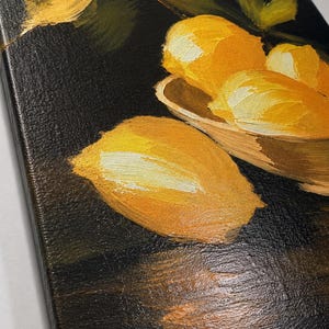 Puede incluir: Una pintura al &oacute;leo sobre lienzo que presenta limones de color amarillo brillante con pinceladas visibles. Varios limones est&aacute;n agrupados en un cuenco poco profundo, mientras que uno descansa sobre una superficie oscura. El fondo es de un negro intenso, contrastando con la fruta amarilla vibrante y las hojas verdes pintadas con una t&eacute;cnica de empaste gruesa y texturizada.