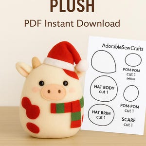 Peut inclure: Peluche de vache de Noël avec un bonnet de Père Noël rouge et une écharpe rouge et verte. La vache a des yeux noirs, un nez rose et des taches rouges. Un patron est visible.