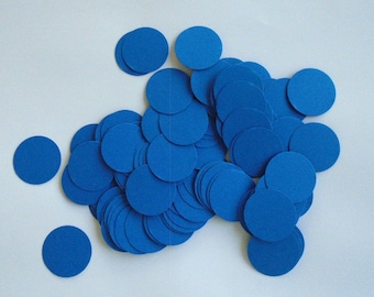 May include: A collection of small, round, royal blue paper cutouts scattered on a white surface. The circles vary in quantity and are of uniform size, creating a visually appealing arrangement.