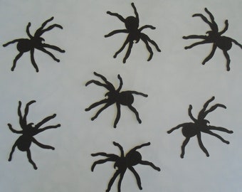 May include: Eight black paper spider cutouts on a white background. The spiders have eight legs and a round body.