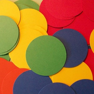 May include: A collection of colorful paper circles in red, yellow, green, and blue. The circles are arranged in a random pattern, creating a visually appealing design.