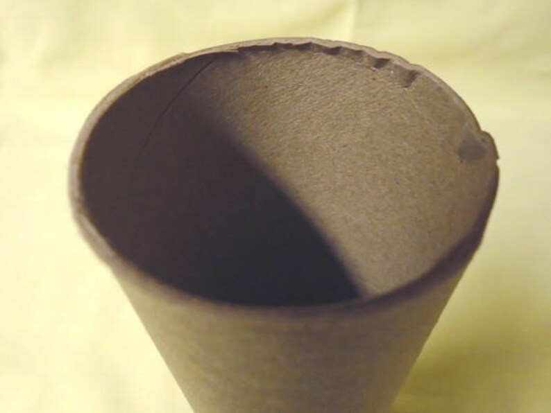 May include: A brown paper cone with a slightly rough texture. The cone is empty and appears to be made from recycled paper.