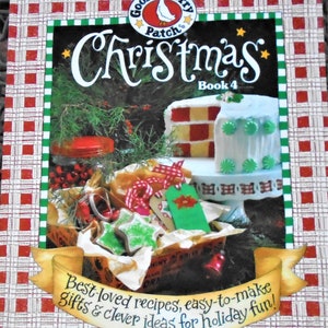 May include: A red and white checkered background with a green border. The book cover features a goose with a red bow tie and the text "Gooseberry Patch Christmas Book 4". The book cover also features a red and white checkered cake with green frosting and a basket of Christmas cookies.