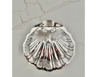 Plato antiguo de plata con forma de concha, fabricado en Inglaterra, con borde festoneado, ideal para guardar objetos pequeños.